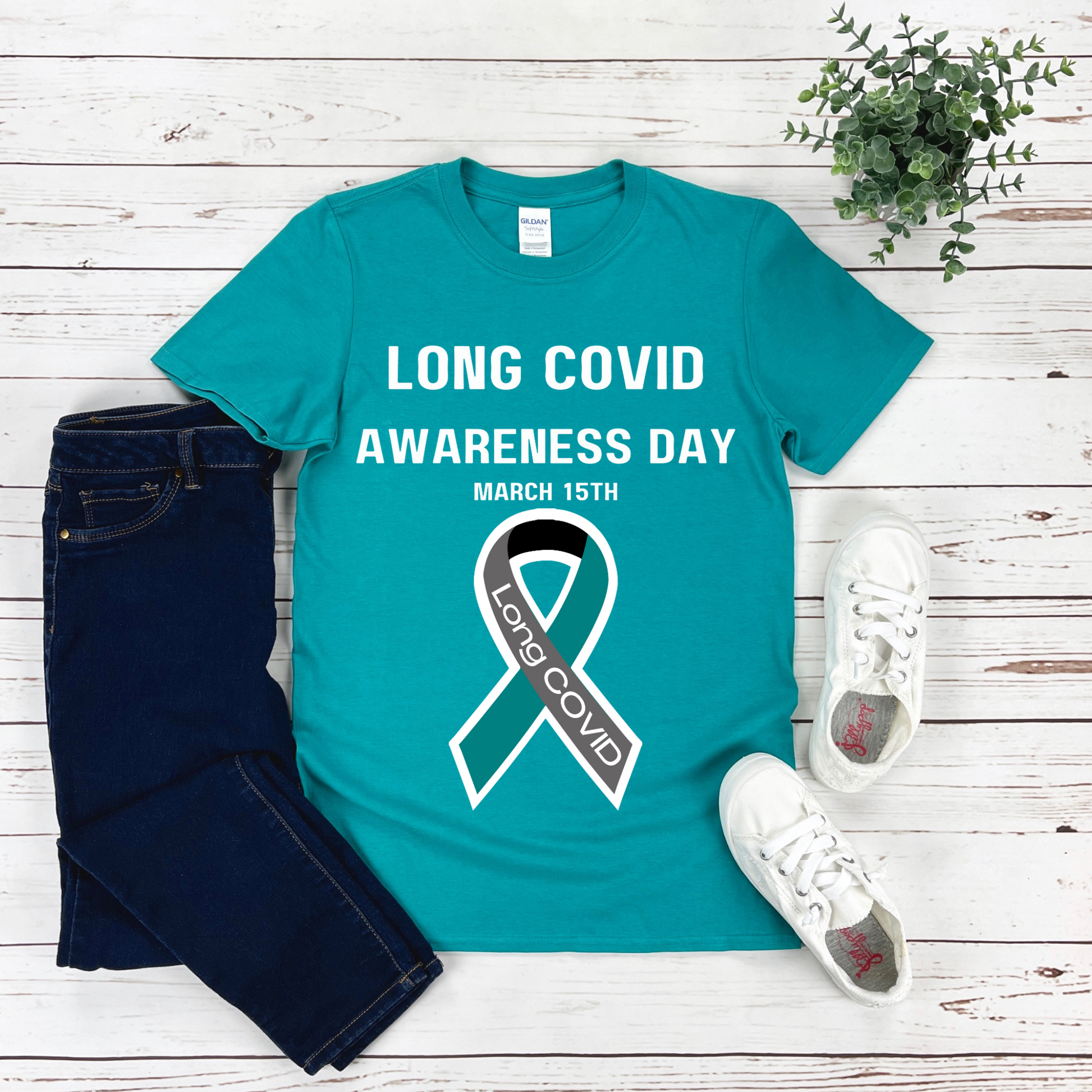 <img alt="teal tee shirt with white text that reads Long Covid Awareness Day, March 15th and a long COVID ribbon in teal gray white and bl" src="#" />